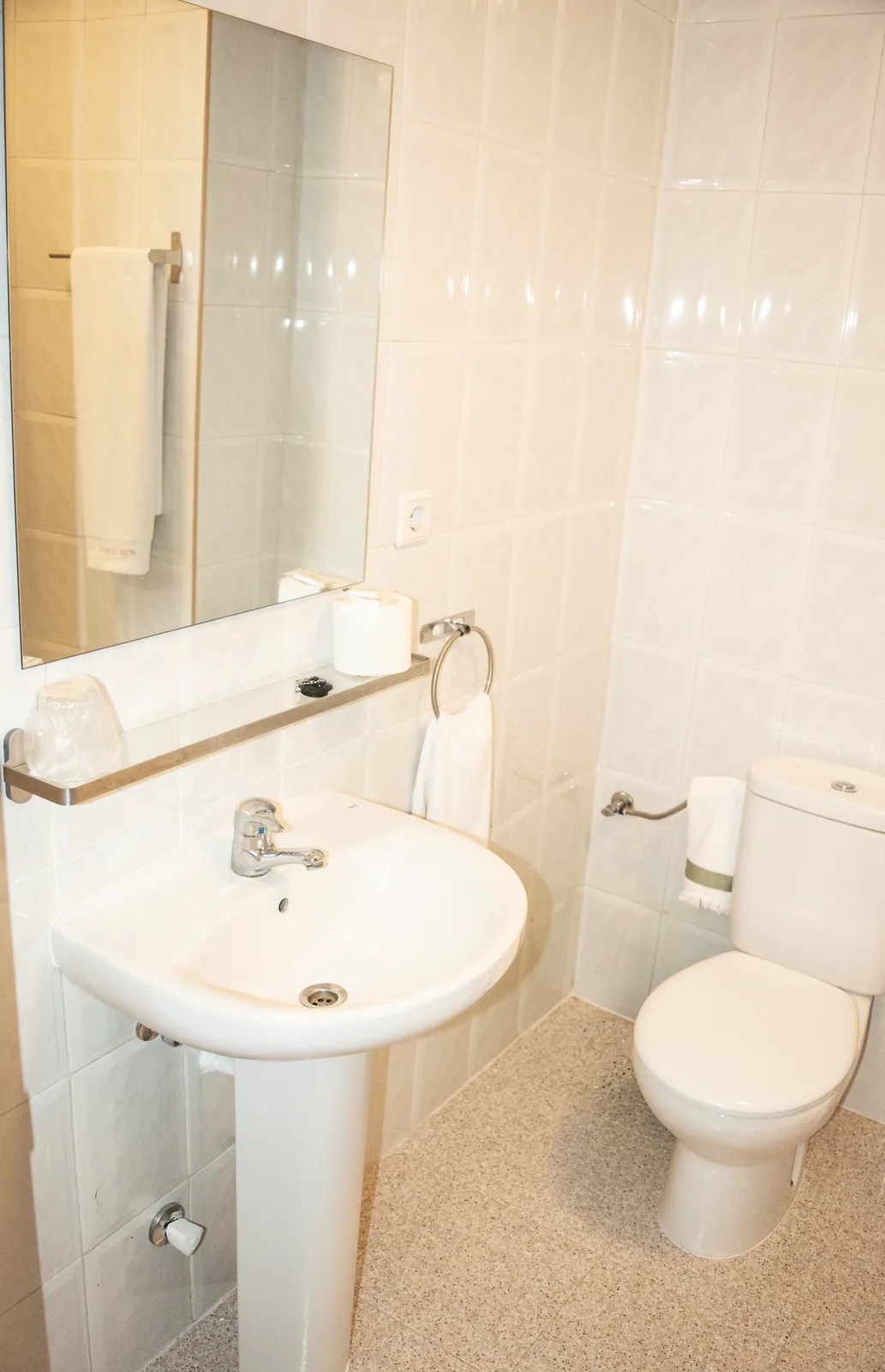 Baño con lavabo, espejo e inodoro
