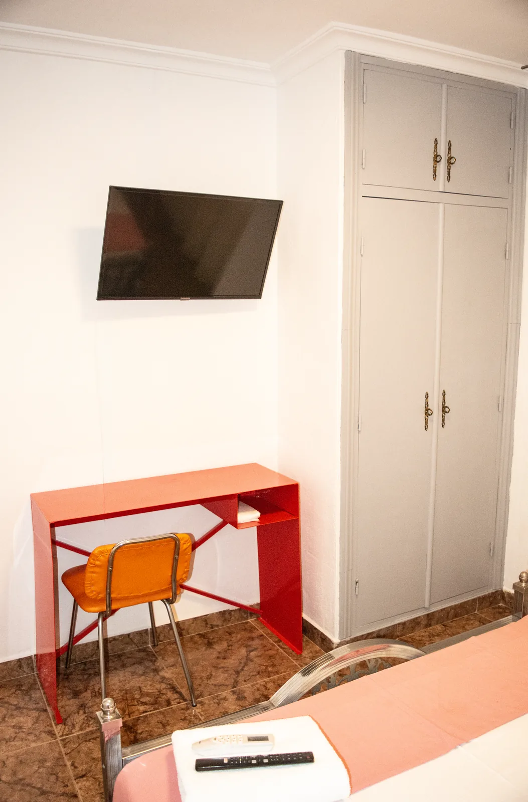 Habitación 102 con escritorio, televisor y armario empotrado