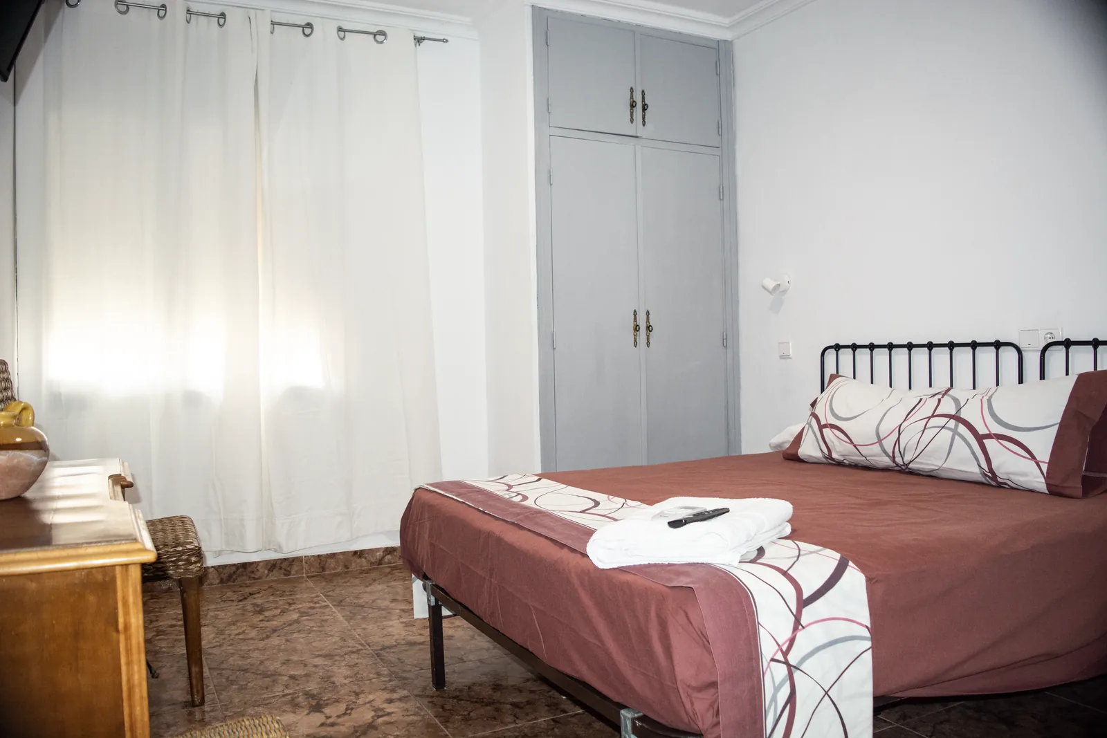 Habitación 104 con cama y cortina de lino junto a la ventana