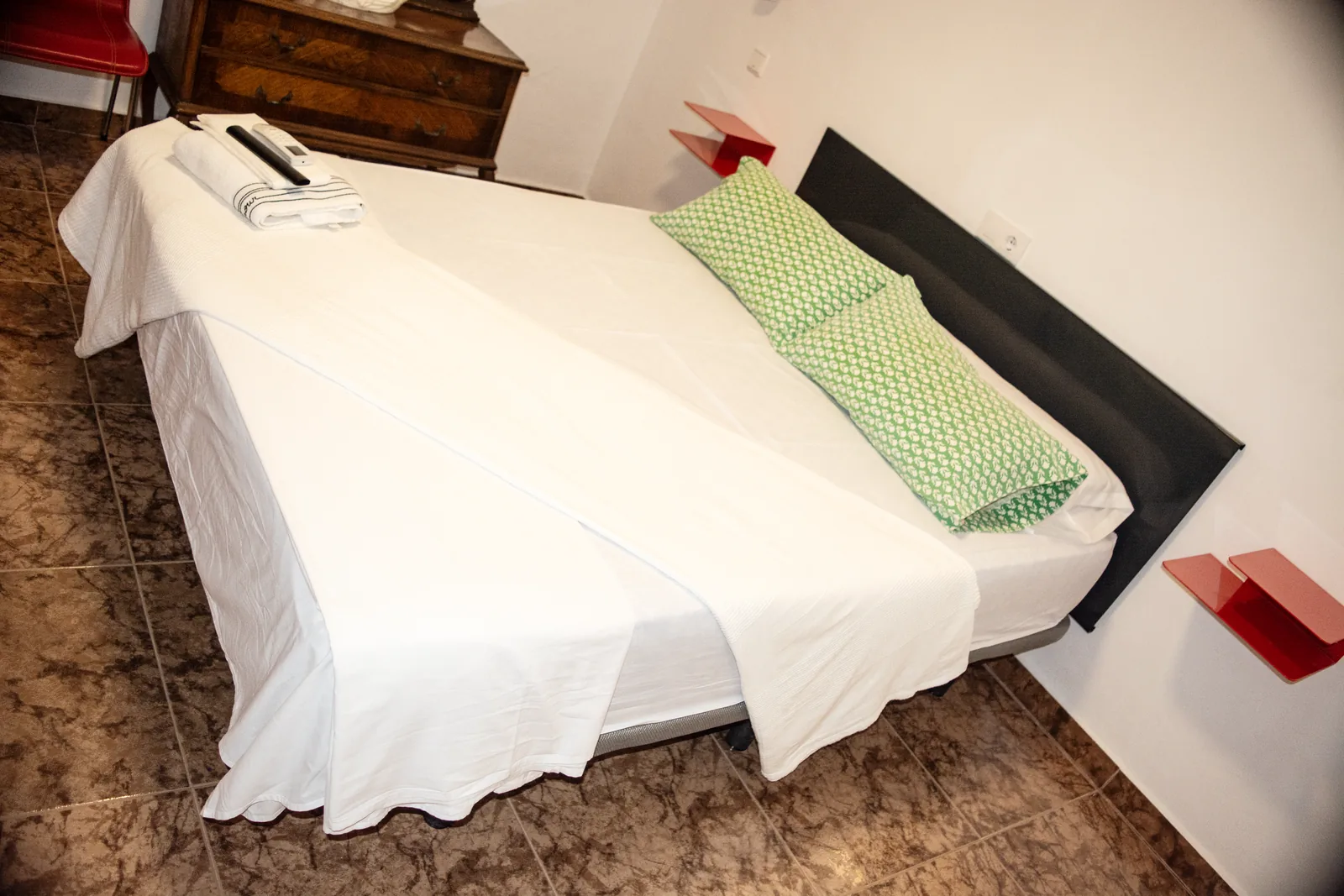 Habitación 105 con cama, espejo de madera tallada y cómoda