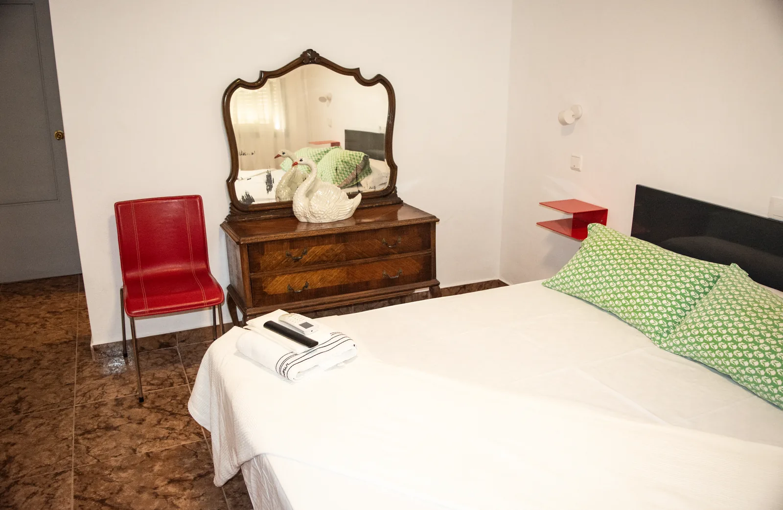 Habitación 105 con cama, espejo y cómoda