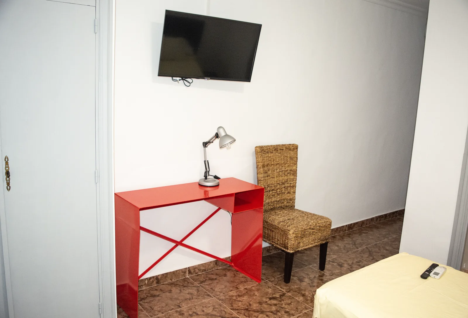Habitación 106 con escritorio, sillón de fibra y televisor