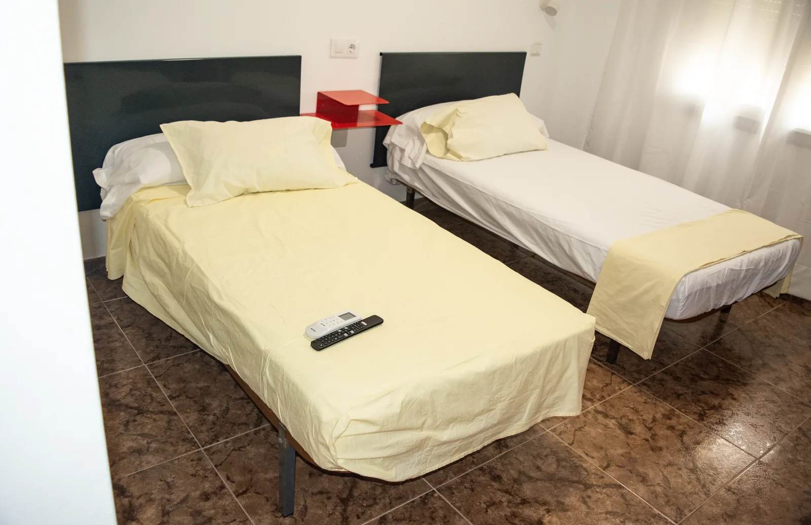 Habitación con dos camas individuales y ropa de cama clara