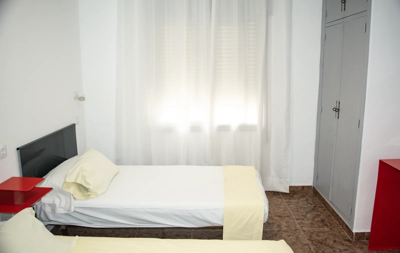 Habitación 106 con cama y ventana con cortina